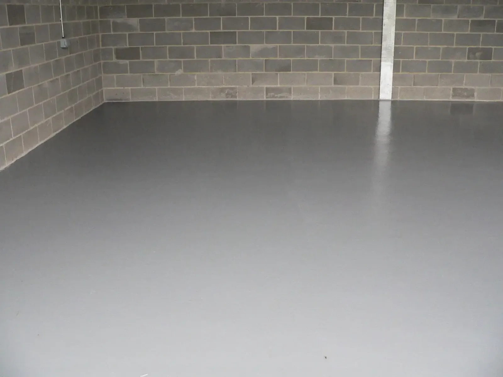 Grey epoxy-coated concrete floor in a vehicle store at Dalham Hall Stud